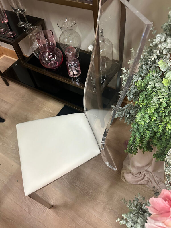 Elegant chair with clear acrylic back and white cushioned seat for weddings and events by SWFL Wedding & Event Rentals Fort Myers, Fl